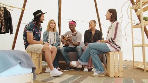 Group of Friends Relaxing and Playing Guitar Indoors