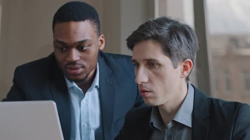 Men Looking at Laptop Screen in Office