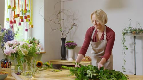 Florist laying out foliage on table