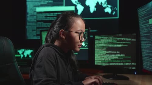 Asian Young Girl Hacker Hacking With Multiple Computer Screens In Dark Room