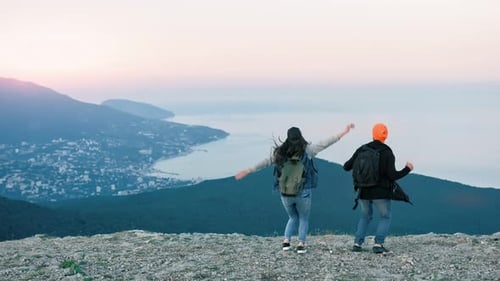 Glückliches Touristenpaar springt und Spaß hat, den Sieg auf dem Gipfel des Berges zu feiern