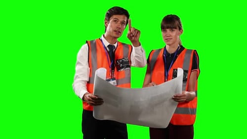 Front view of a site workers looking at a site map with green screen