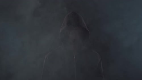 Retrato de hacker informático con capucha. Rostro oscuro oscurecido.