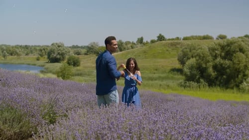 Unbeschwertes Paar gemischter Rassen, das Spaß im Feld hat