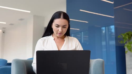 Young Woman Celebrating Success in Modern Office