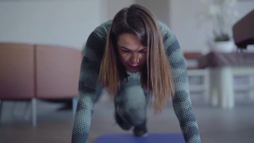 Front View of Happy Confident Young Woman Training on Exercise Mat at Home or in Gym. Portrait of