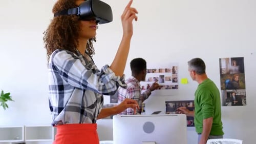 Pretty mixed-race female executives using virtual reality headset in modern office 4k