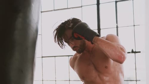 Muscular Man Punching a Punching Bag