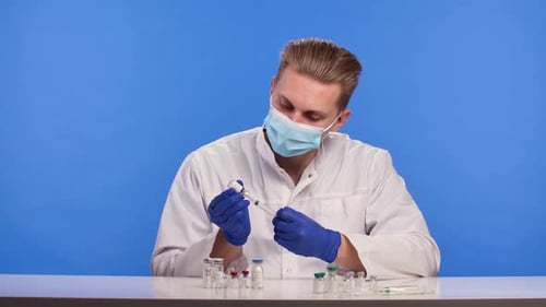 Scientist Filling Syringe From Vial in Lab