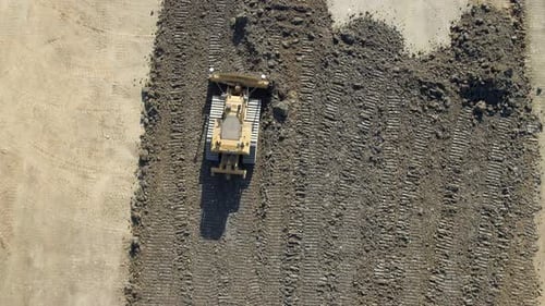 A Bulldozer Moving Earth to Flatten it for Construction