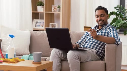 Man Shopping Online with Laptop and Credit Card at Home
