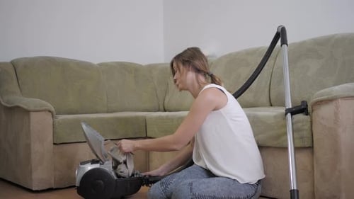 Allergies domestiques, une fille assise sur le sol souffre et éternue à cause de la poussière après avoir nettoyé la maison avec