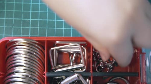Skilled Tailor Takes Silver Clasps From Red Container Close