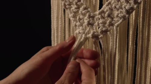 Women's Hands Weave a Macrame Pattern in Creative Workshop on Black Background