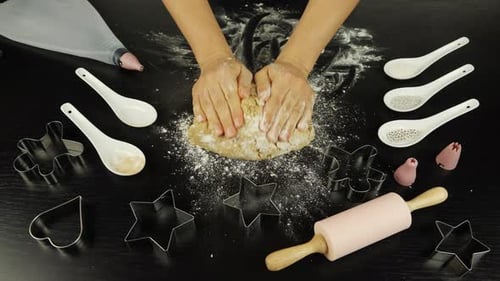 Woman is kneading raw dough for bakery