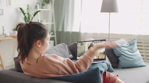 Woman Video Calling Friend on Laptop at Home