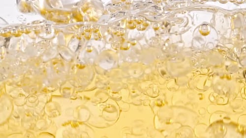 Bubbles Rising Through Golden Viscous Liquid Close-Up