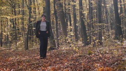 Stylish Young Woman in Jacket and Jeans Walking in the Autumn Park Alone