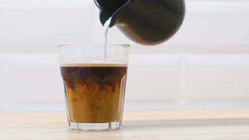 Milk Poured Into Coffee Glass Close Up
