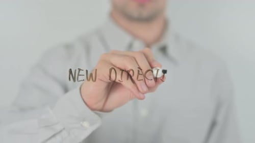 Man Writes 'New Direction' on Transparent Surface