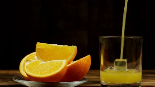 Fresh Orange Juice Pouring Into Glass With Ice
