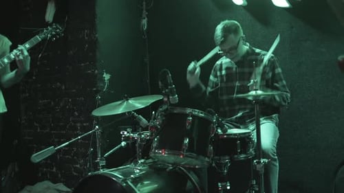 Drummer Playing a Set of Drums and Cymbals