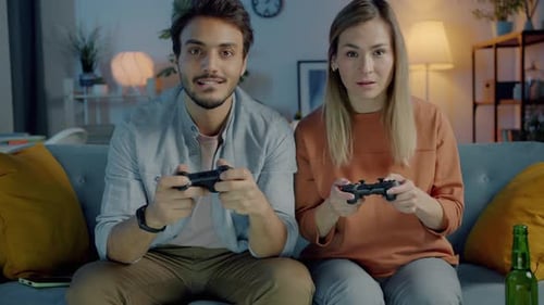 Couple Playing Video Games at Home on Couch