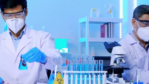 Scientists Working with Beakers and Microscope in a Lab