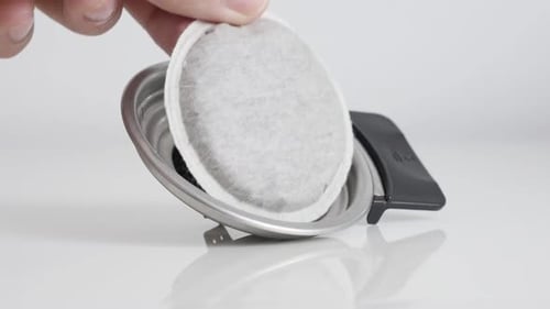 Adding Coffee Pod to Silver Holder Close Up