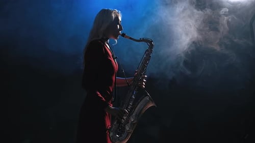 Woman Plays Saxophone in Smoky, Blue-Lit Room