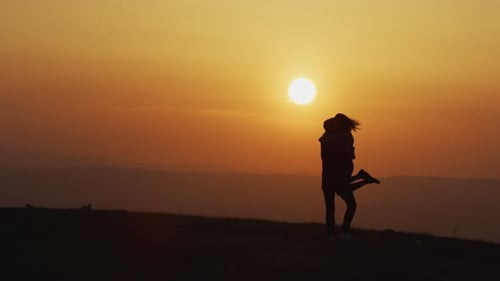 Couple Embracing in Silhouette at Sunrise