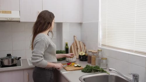 Woman Chopping Vegetables in Bright Kitchen for Salad