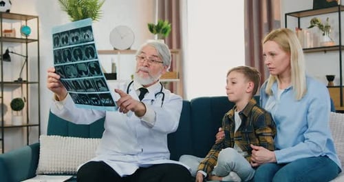 Un médecin rend visite à un patient garçon et à sa mère à la maison pour expliquer les résultats de la radiographie