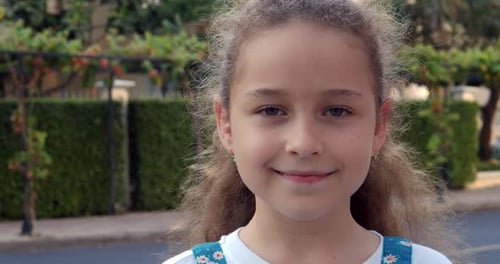 Portrait Cute Little Child Girl Looking at Camera Standing on Street in City on Summer Day