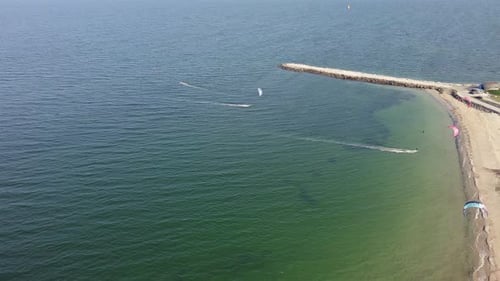People in Sportswear on Kiteboards Ride on the Black Sea in Bulgaria
