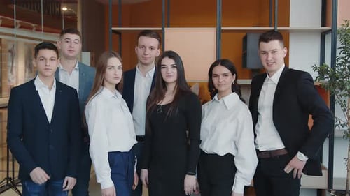 Team of Young Professionals Giving Thumbs Up Indoors