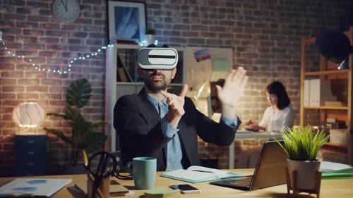 Excited Businessman Enjoying Ar Glasses in Dark Office at Night Laughing