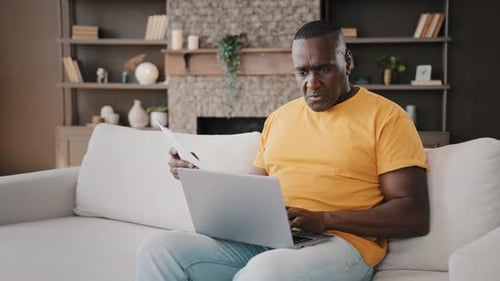 Adult Man Working at Home with Laptop