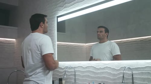 Homem bonito se motivando no banheiro. Retrato do homem de auto-motivação.