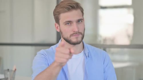 Man Points and Smiles at the Camera