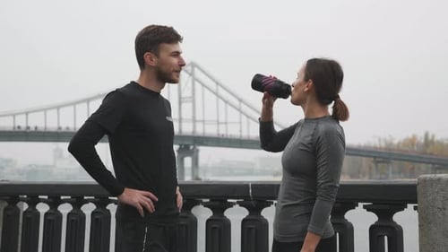 Man and Woman Chatting and Exercising Outdoors