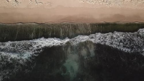 Aerial Top View of Ocean Waves Break on a Beach