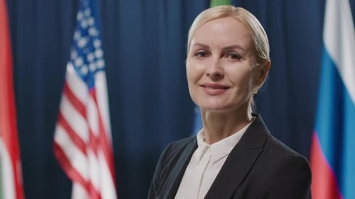 Professional Woman Smiling in Front of International Flags