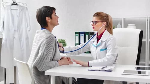 Doctor Listens to Patient's Heart with Stethoscope in Clinic