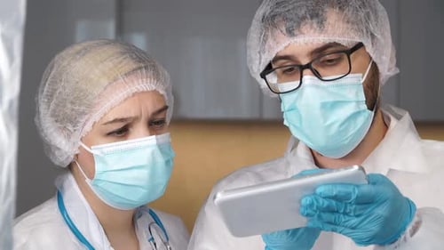 Team of Doctors Discuss Patients Diagnosis on Tablet in Hospital