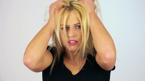Une jeune femme séduisante tremble et attrape ses cheveux avec fureur - Face Closeup - White Screen Studio