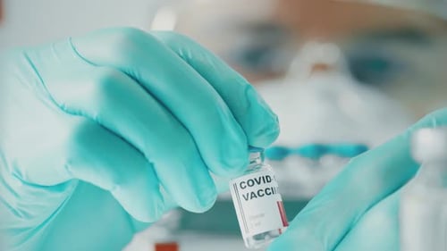 Scientist Holding COVID-19 Vaccine Vial in Lab