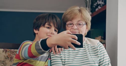 Child Taking Selfie with Grandmother Indoors