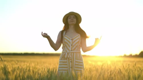 Young Woman Enjoys Sunset in Wheat Field