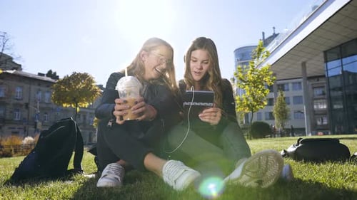 Happy Teenage Friends Using Tablet Computer Computer at Park